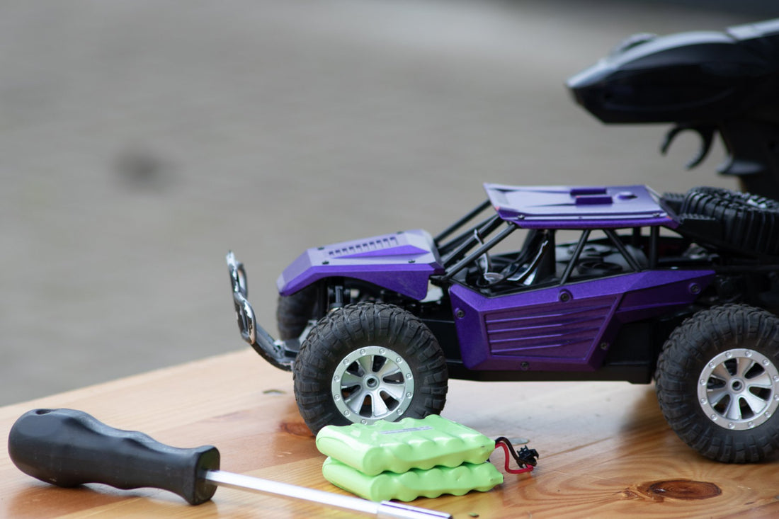 Purple RC car with batteries on a table top