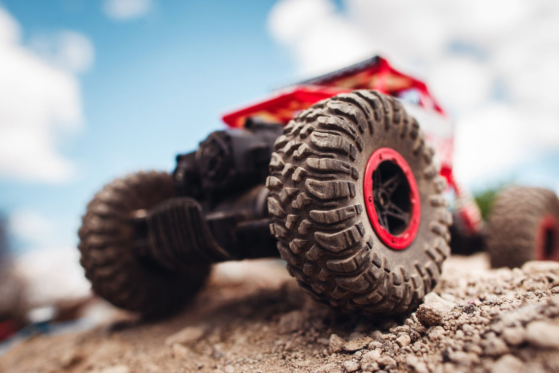 Red RC car closeup on dirt ground